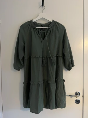 Grön klänning från Vero Moda - Jättefin mörkgrön klänning från Vero Moda i storlek S med en vid och kort passform🤍Klänningen är endast använd ett fåtal gånger, och är i väldigt bra skick☺️OBS! Sista bilden är en annan liknande klänning från Vero Moda för att få förståelse för hur klänningen ser ut på, (då den tyvärr är för liten för mig)🥰