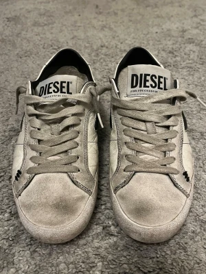 Diesel skor - Tja säljer ett par Diesel skor i storlek 40. Skorna har mycket slitningarna och i skon som man kan se på bilderna. Nypris 2400 kr och jag säljer för 300 kr. Skorna finns ej på hemsidan längre. Jag har ingen box på skorna kvar. Snörena är inye så korta som på bilden utan ligger en del i skon. Skriv till mig vid minsta fundering!!