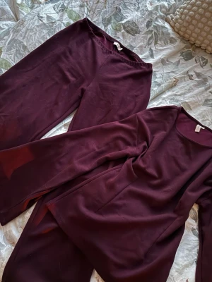 Vinrött Nelly det - Jättesnyggt och mysigt vinrött set från Nelly som verkligen får fram figuren! Går att både klä upp och klä ner 🎀 Byxorna är lågmidjade och tröjan figursydd med utsvängda ärmar ❣️Nypris för byxorna och tröjan sammanlagt är 700kr 🌺Använt 1 gång så i nytt skick ☺️ Båda delarna är i storlek XS!