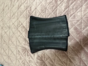 Svart midjetränare shapewear - Svart midjetränare i shapewear-modell med flera rader hakar för justerbar passform. Tillverkad i elastiskt material med en slät yta och förstärkta sömmar. Perfekt för att forma midjan under kläder. Märke och storlek saknas.