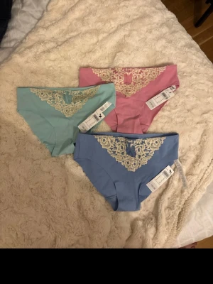 3-pack trosor med spets, Intimissmi strl S - Säljer tre superfina trosor från Intimissimi i storlek S. Alla är helt nya och har kvar lappen.  Färger: Rosa, blå, turkos/mintgrön  Mjukt och skönt, stretchigt material med fin spetsdetalj framtill. De har inga kanter/sömmar vid sidorna, vilket gör att de inte syns under byxor eller tighta kläder.  Säljs som paket (alla tre tillsammans). Köptes för ca 200 kr st  Hör av dig vid frågor!