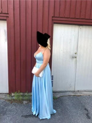 Ljusblå balklänning / aftonklänning – Dressroom Linen – Strl XL (44) - Jättefin ljusblå balklänning som är endast använd en gång på min bal. Klänningen är i väldigt fint skick, som ny.  ✨ Från Dressroom Linen ✨ Storlek XL / EU 44 ✨ Originalpris: 3990 kr ✨ Snörning i ryggen som gör att passformen kan justeras ✨ Elegant och smickrande modell med fint fall  Perfekt som balklänning, aftonklänning, festklänning, bröllopsgäst-klänning, gala eller annan högtid. En riktigt lyxig och tidlös klänning som sticker ut.  Skicka gärna meddelande om du har frågor 💙  