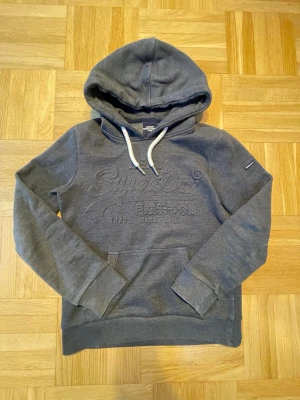 Mörkgrå hoodie från Superdry - Mörkgrå hoodie från Superdry i storlek Xs och passar typ 165.