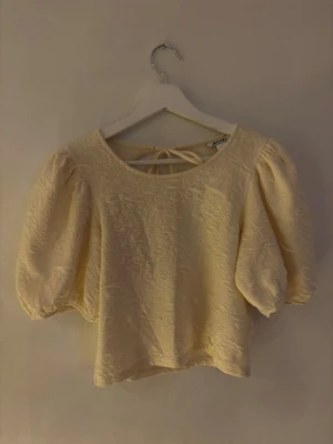 Gul topp från Monki - Kortare gul topp med puffärm och öppen rygg från Monki. Använd 1 gång, sorlek S!
