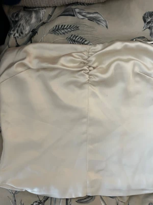 Champagnefärgad tubtopp från Bik Bok - Snygg champagnefärgad tubtopp från Bik Bok x Lovisa Barkman i glansigt satinmaterial. 🥂