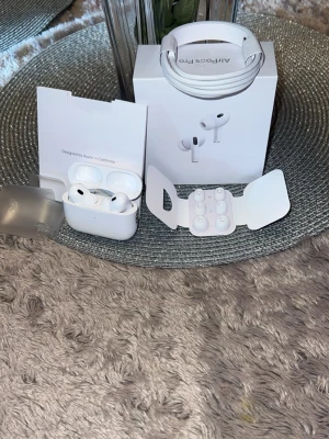 Apple AirPods Pro med tillbehör - Säljer ett par vita Apple AirPods Pro med laddningsetui, extra silikontoppar i olika storlekar och en vit USB-C laddningskabel. Snygg och stilren design i plast och silikon, perfekt för dig som vill ha trådlösa in-ear hörlurar med bra ljud och brusreducering. Använt bara 2 gånger då ja fick dem i julklapp och de har bara legat hemma(: