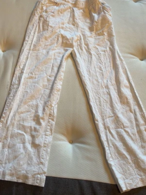 Vita linnebyxor med resårmidja - Snygga vita linnebyxor med avslappnad passform och resår i midjan. Byxorna har raka ben och sidfickor, perfekta för en chill och stilren look. Tillverkade i luftigt linnematerial som känns fräscht och bekvämt.