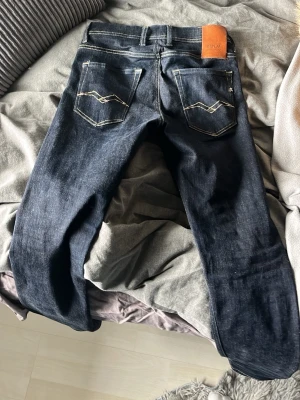 Mörkblå replay jeans  - Säljer ett par mörkblå jeans från Replay med snygga kontrastsömmar och klassiska fem fickor. Jeansen har raka ben och en skinnpatch med Replay-logga bak i midjan. Materialet är slitstarkt jeans och passformen är normal 
