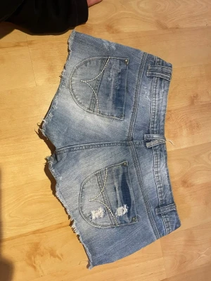 Lågmidjade jeansshorts vintage - Midjemått 39/40 cm. Coola lågmidjade jeans short i fint skick! Hör av er mid frågor!