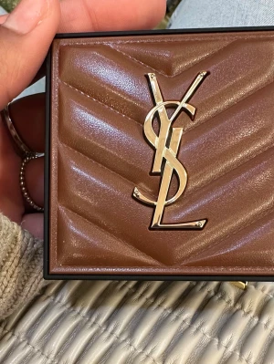 YSL All Hours Hyper Bronze 04 - Snygg bronzer från Yves Saint Laurent i nyansen 04 Warm Sandalwood. Kommer i en lyxig brun och guldig förpackning med YSL-logga. Puderform med hyaluronsyra för en fräsch och naturlig glow. Perfekt för att ge ansiktet värme och definition. OBS!HELT NY RÅKADE KÖPA DUBBLA. Ej testad!!