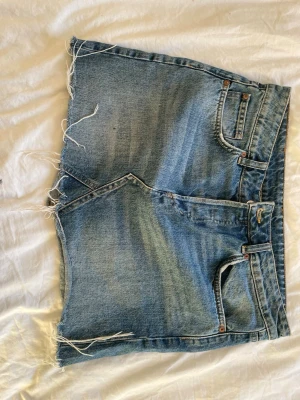 Blå jeanskjol med fransig kant - Fin jeanskjol från hm med disstressed hem nedtill. Jätteskön på sommarn. Priset kan förhandlas💕
