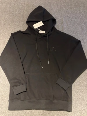 En snygg svart hoodie - Snygg hoodie. Aldrig använd helt ny, om ni är intresserade är det bara att höra av sig. Det är storlek M men passar mer som S