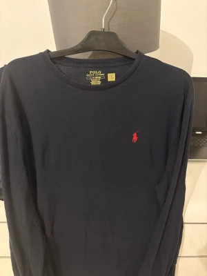 Mörkblå långärmad tröja Polo Ralph Lauren - Snygg mörkblå långärmad tröja från Polo Ralph Lauren i klassisk passform. Storlek L, priset kan diskuteras. Levereras inom 24 tim