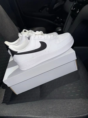 Nike Air Force 1 '07 Vita/Svarta Sneakers, Strl 44 - Helt nya Nike Air Force 1 '07 Vita/Svarta Sneakers, Strl 44.  Skorna har inte blivit använda eller testade.  Original kartong medföljer. Nypris hos Nike 1400 kr