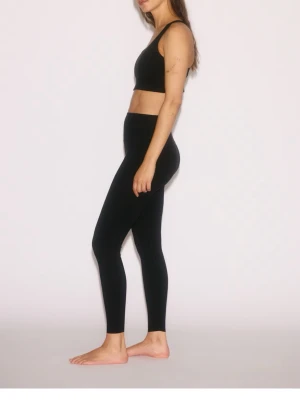Svarta höga leggings - Snygga svarta leggings med hög midja och tight passform. De är helsvarta utan synliga loggor eller detaljer och har en klassisk, stilren look. Perfekta för att matcha med crop tops eller oversized tröjor. Materialet ser ut att vara stretchigt och bekvämt.