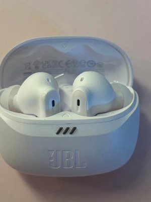 JBL vita trådlösa in-ear hörlurar - Säljer ett par snygga vita trådlösa in-ear hörlurar från JBL. De kommer med ett matchande laddningsetui i plast och har en stilren, modern design. Perfekta för musik, poddar eller samtal på språng. Använd 1 gång 