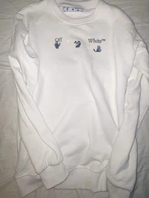 Vit sweatshirt från Off-White - Säljer en clean vit sweatshirt från Off-White med tryck på bröstet och klassisk rund hals. Tröjan har ribbade muddar vid ärmslut och nederkant. Perfekt för dig som gillar streetwear och vill ha något stilrent från ett populärt märke.