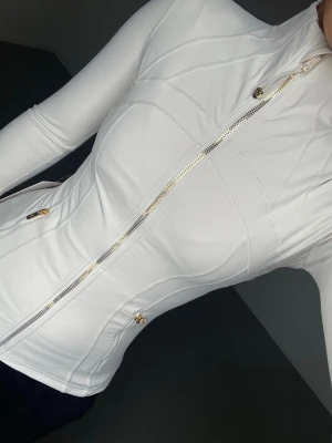 Lululemon define jacket gold zipper - Endast använd fåtal gånger, säljs då den inte kommer till användning. I färger ivory/gold, sällsynt färg! Storlek 4 motsvarar XS-S