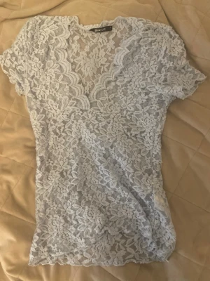 Blå spets topp - Snygg blå v ringad spets topp från Gina tricot i storleken S. Perfekt för sommaren och fester.