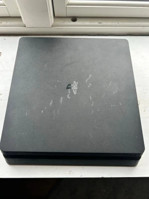 Sony PlayStation 4 Slim svart - Säljer en svart PlayStation 4 Slim från Sony. Konsolen har en stilren, fyrkantig design med matt finish och PlayStation-loggan på ovansidan. Tillverkad i plast och passar perfekt för gaming och underhållning (ingen ps4 dosa med)