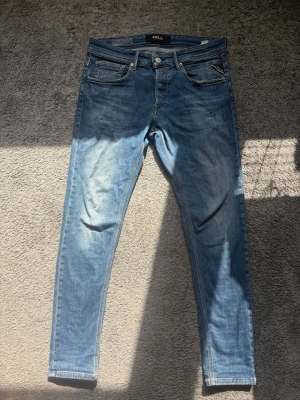 Replay anbass jeans - Snygga blå slim fit jeans från Replay modell anbass, med ljustvätt design och slitningar. Storlek 30/32, rimligt prisförslag kan diskuteras vid snabb affär✅
