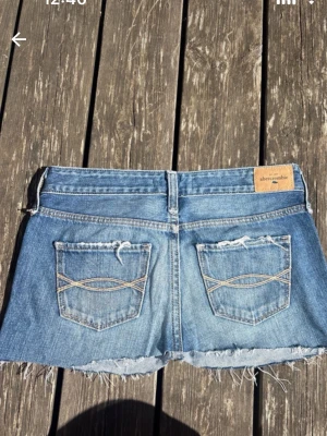 Lågmidjad jeanskjol   - Midjemått 35cm och längd 25 cm 