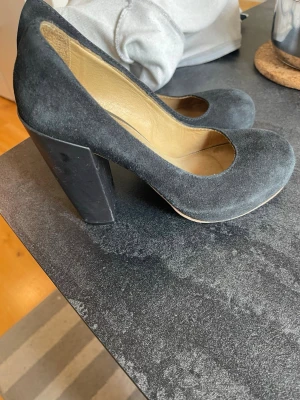 Acne Svata pumps med bred klack stl 39 bra skick - Acne Stilrena svarta pumps med rund tå och bred hög klack. Ovandelen är i mocka och insidan i ljust läder. Perfekta för dig som gillar en klassisk look med lite extra höjd.