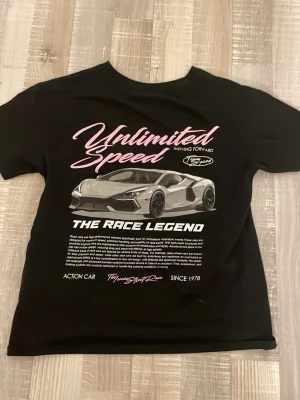  t-shirt med tryck - säljer en helt oanvänd cool svart t-shirt med tryck av en sportbil och texten 'Unlimited Speed' i rosa och vitt framtill. Stort motiv på ryggen och mindre logga på bröstet❤️