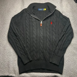 Svart kabelstickad tröja Polo Ralph Lauren - Kabelstickad svart tröja från Polo Ralph Lauren med halv dragkedja. Den är i mycket bra skick. Skickar snabbt efter att du har beställt. Frågor? Skicka ett meddelande.