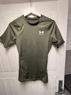 Grön kompressionströja Under Armour - Säljer min compression tröja från under armar. Den är  i storlek S. Säljer då den är för liten. Jag är 180 och väger ish 83kg. Skulle säga du bör vara 175 ish och väga kanske 72-77 kanske för att få den att sitta riktigt bra, men de skiljer sig från person till person. Bara att skriva vid frågor. 