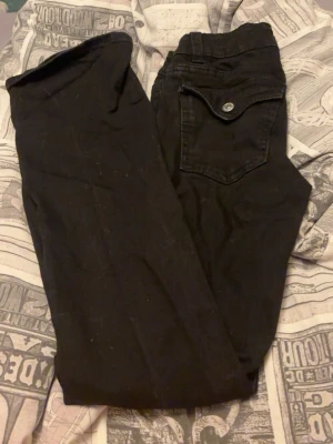 Svarta jeans från Perfect Jeans - Svarta jeans från Perfect Jeans med klassisk femficksdesign och snygg knappdetalj på bakfickan. Jeansen har dragkedjegylf och bälteshällor. Perfekta till din vardagsstil och lätta att matcha med allt. Materialet är mjukt och stretchigt för extra komfort.