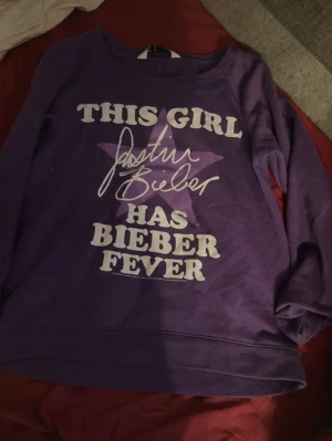 Lila Justin Bieber sweatshirt - Lila sweatshirt från I ♥ Justin Bieber, enkel design utan tryck på framsidan. Mjuk insida och rund halsringning, perfekt för dig som gillar bekväma och stilrena tröjor. Passar dig som vill visa ditt JB-fan-hjärta.