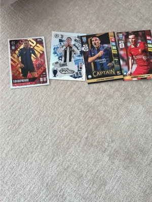 Fifa fotbollsspelkort 4-pack - Fyra coola fotbollsspelkort från Topps med olika spelare från kända europeiska klubbar. Korten har färgstarka designer, klubbmärken och spelarporträtt. Perfekt för samlare eller att använda i fotbollsspel. Materialet är glansig kartong.