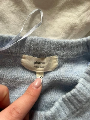 Ljusblå stickad tröja Gina Tricot - Mysig ljusblå stickad tröja från Gina Tricot i ullblandning. I storlek L men krympt i tvätten så skulle mer säga M, lite nopprig men går att få bort💗