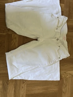 Vita utsvänga jeans från Gina tricot  - Säljer ett par vita jeans från Gina med utsvängda ben och klassiska fyra fickor. Jeansen har låg midja och tydliga sömmar på bakfickorna. Jeansen är helt nya. Köparen står för priset + frakten. 