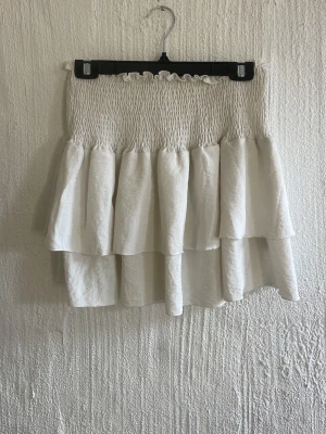 Vit volangkjol - Enkel vit volangkjol som passar till allt o är perfekt för sommaren🥰Jätte bra skick, använt 2 gånger kanske? Säljer då jag har två st! Den är strechig men ändå tajt så passar xs-m! Köpte på loppis utan lapp för 190kr så vet ej vart den är ifrån men skulle gissa på veromoda??