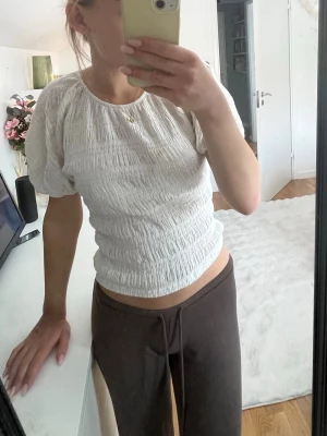 Vit smockad topp med puffärm - Vit smockad topp med puffärm, aldrig använd. Storlek M på lapp men sitter som en S