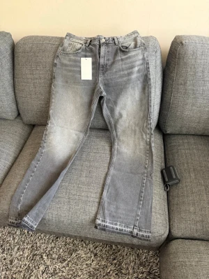 Mörk gråa flared jeans ifrån Zara - Säljer ett par grå jeans från Zara med flared. Jag har inte använt dessa brallor en enda gång, dem är för små på mig