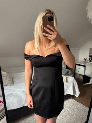 Svart klänning - Superfin svart mini-klänning med off-shoulder design. Väldigt skön i materialet, endast använd en gång😊