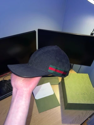 Svart Gucci keps - Säljer en svart keps från gucci i nyskick, kepsen är äkta och kvitto finns. Alla tillbehör följer med. Vid fler bilder/frågor är det bara att höra av sig, pris går att diskutera.