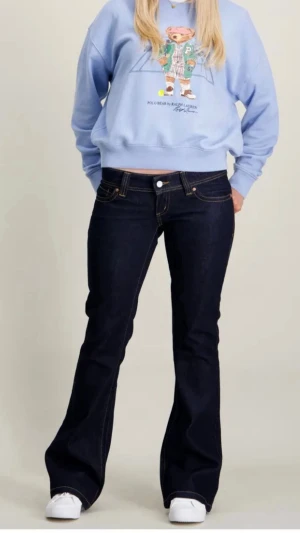 ABRAND SUPER LOW KICK Mörkblå bootcut jeans - Skit snygga mörkblå bootcut jeans från ABRAND i modell 00 SUPER LOW KICK. Med klassiska fem fickor och kontrastsömmar. Jeansen har låg midja och utsvängda ben, perfekt för en trendig och avslappnad look. Storlek W24. Mina absolut favorit byxor, knappt använd då de köptes i en något för liten storlek