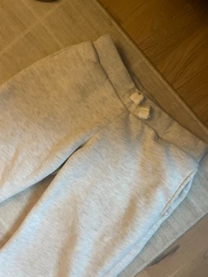 Vita mjukisbyxor med dragsko  - Säljer ett par vita mjukisbyxor med låg midja och dragsko i midjan. Byxorna har en avslappnad passform och är perfekta för chill dagar. Mjukt material som känns skönt mot huden.