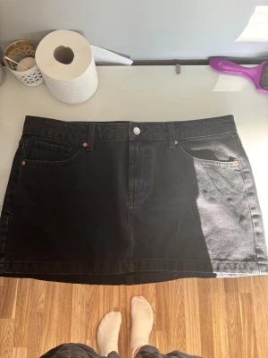 Svart jeanskjol mango - Snygg svart kort jeanskjol med klassisk femficksdesign och bälteshällor. Rak modell med knapp och dragkedja framtill. Perfekt att matcha med en t-shirt eller hoodie för en avslappnad look.