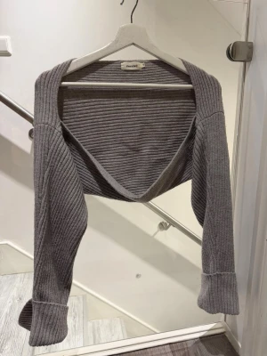 Grå bolero från Missay - Säljer en grå ribbstickad bolero från Missay. Modellen har långa ärmar, perfekt att slänga över en topp eller klänning. Materialet är mjukt och följsamt, med breda muddar vid ärmslut. Enkel och stilren design som passar till många outfits💖