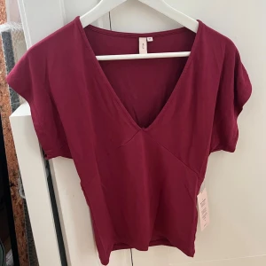 Vinröd topp - Vinröd topp från Nelly i storlek XS. Endast provad, med lapparna kvar. 
