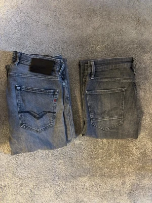 PAKET❗️2 par grå jeans från Replay och Jack&Jones - PAKET❗️Säljer 2  par grå slim fit jeans från Replay och Jack&jones då de har blivit för småa för mig. Diskreta slitningar. Jeansen är tvättade fåtalet gånger och sitter bra i passform. Replay storlek 31/32 Jack&Jones storlek 31/30