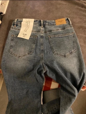 Blå flared jeans Urban Revivo - Säljer ett par blå flared jeans från Urban Revivo i storlek S 26. Jeansen har klassisk femficksdesign, ljusblå tvätt och utsvängda ben. Materialet är denim och de har en snygg retrostil som är perfekt för dig som gillar trendiga jeans.