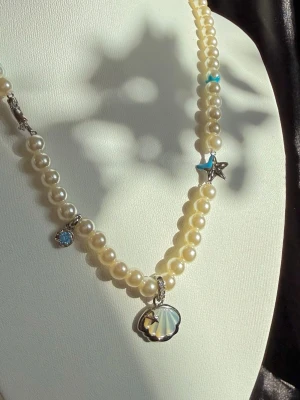 Handgjort Pärlhalsband med Snäcka, sjöstjärna - Pärlhalsband mef snäckor och sjöstjärnor detaljer🐚☀️Tål vatten! 🌊✨