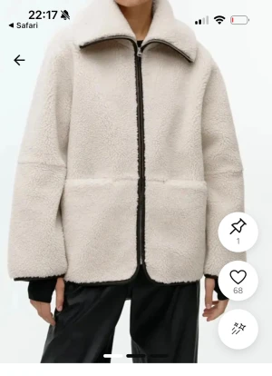 Beige teddyjacka med dragkedja - Mysig beige teddyjacka med hög krage och svart dragkedja framtill. Jackan har en boxig passform och är tillverkad i fluffigt teddy-material som ger en cool och avslappnad look. Perfekt för att hålla sig varm under kyliga dagar.