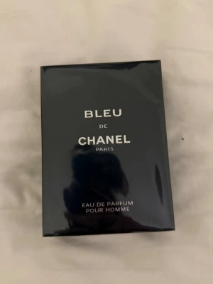 Bleu de Chanel Eau de Parfum - Bleu de Chanel Eau de Parfum Pour Homme är en elegant herrparfym från Chanel. Förpackningen är mörkblå med vit text och har en stilren, rektangulär form. Perfekt för dig som vill ha en klassisk och maskulin doft från ett lyxigt märke.